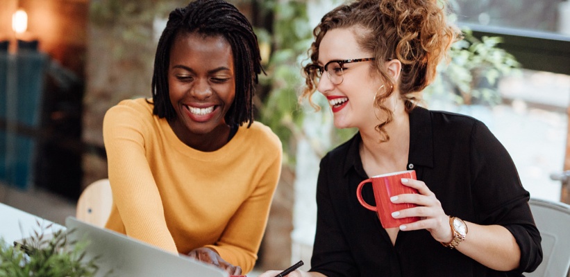 two female coworkers smiling